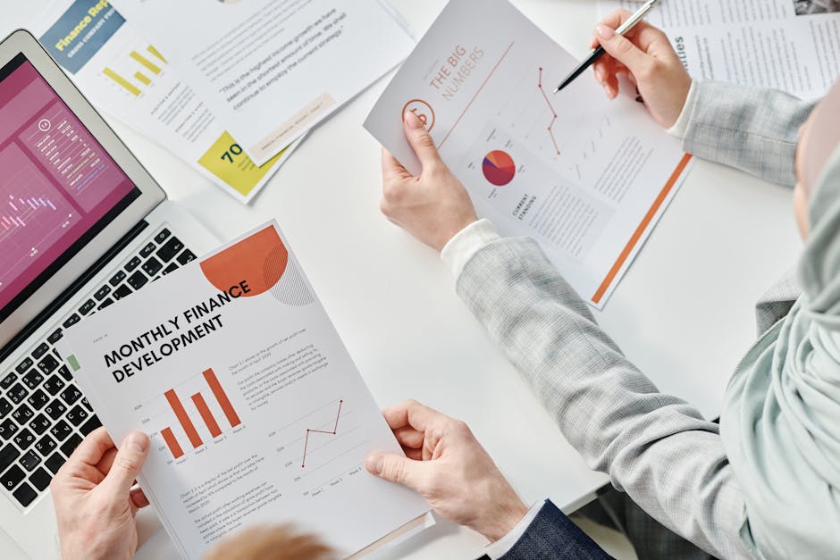 Top view of business colleagues analyzing financial reports during a meeting at the office.