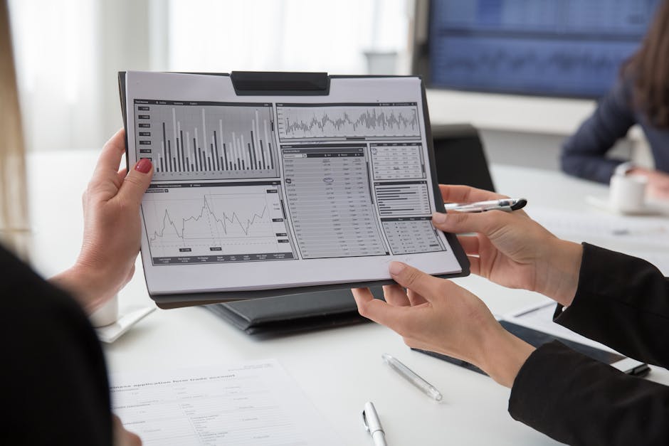 Professionals reviewing data charts on paper during a business meeting.